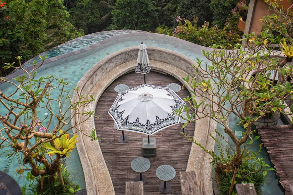 Blogger writing about cantilever umbrellas beside a serene garden patio