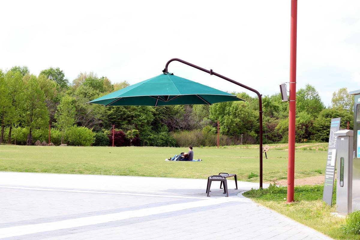 Diagram comparing traditional center-pole umbrella vs. cantilevered umbrella showing unobstructed seating area under cantilever design
