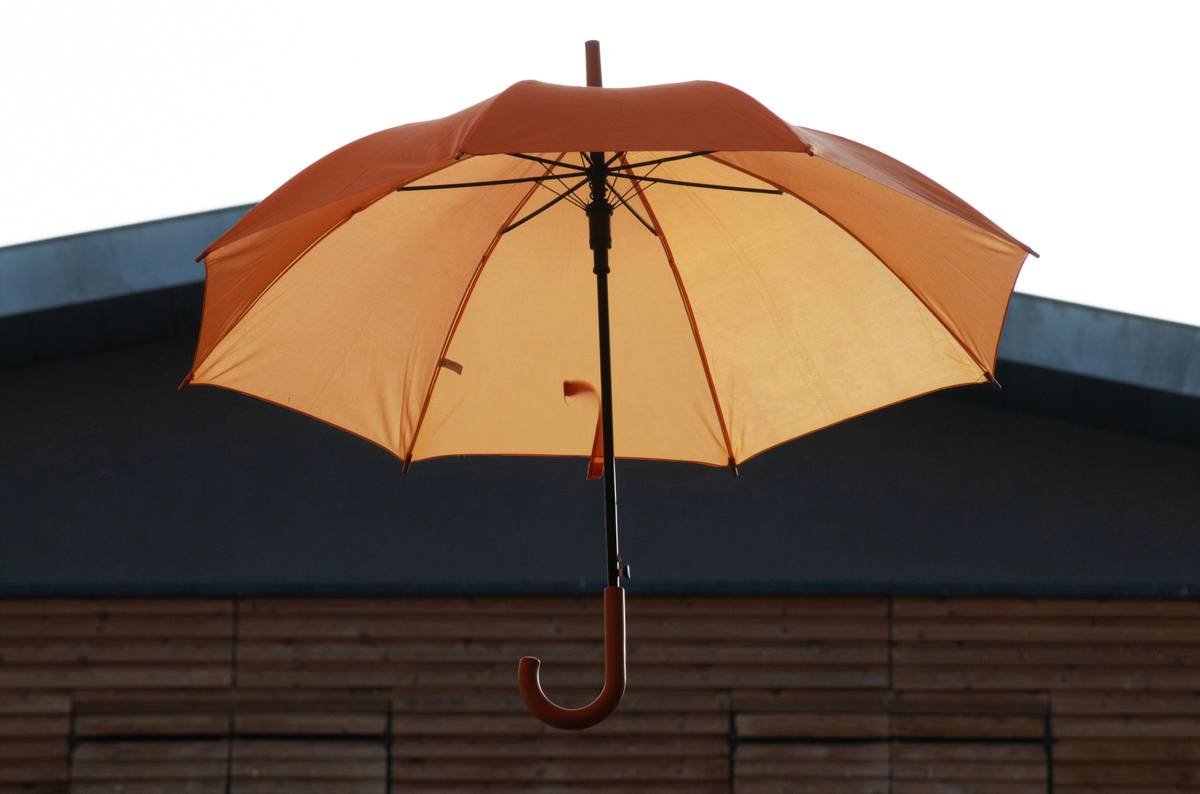 Infographic showing key windproof features of cantilever umbrellas: vented canopy, double ribs, 360-degree rotation lock, weighted base, and tilt mechanism